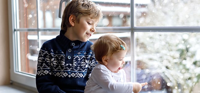 Bild: zwei Kinder im Winter am Fenster